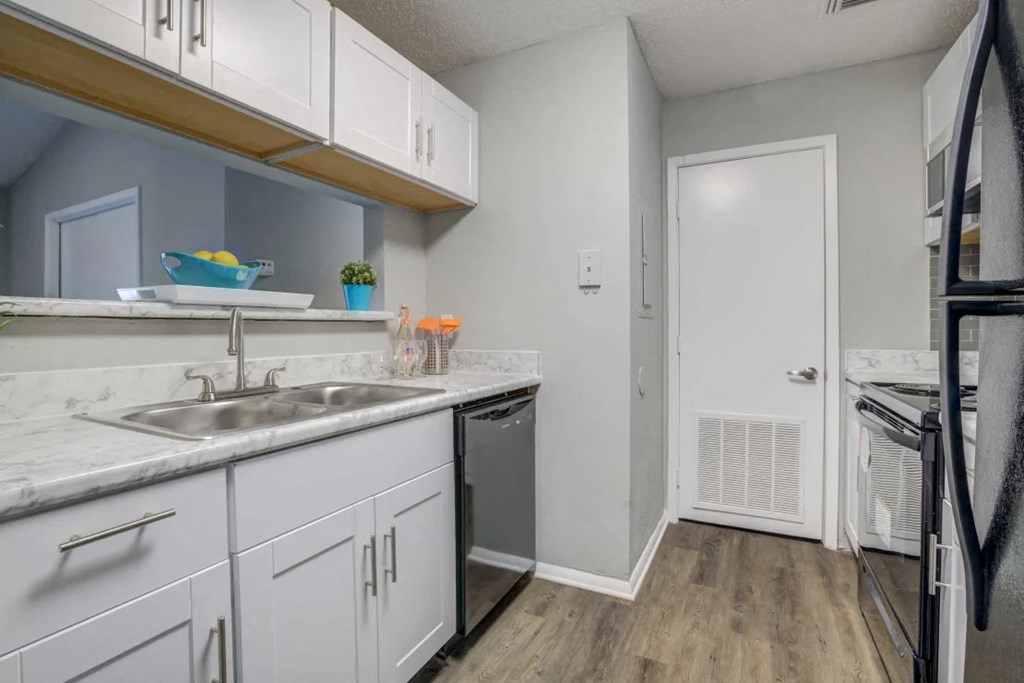 a kitchen with white cabinets and a sink and a refrigerator