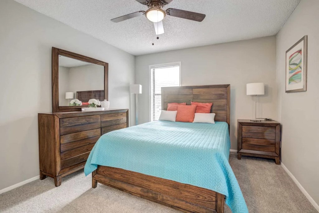 a bedroom with a bed and a ceiling fan