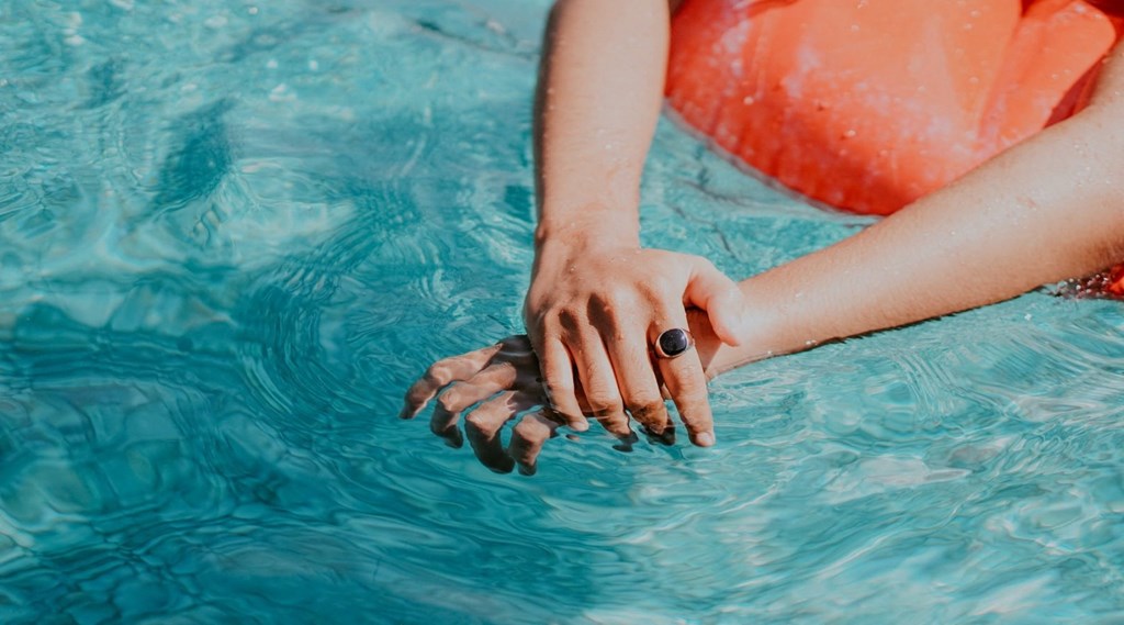 a woman holding her hands in the water in a pool