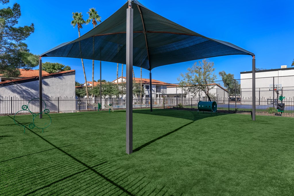 a large shade sail in a backyard with a playground