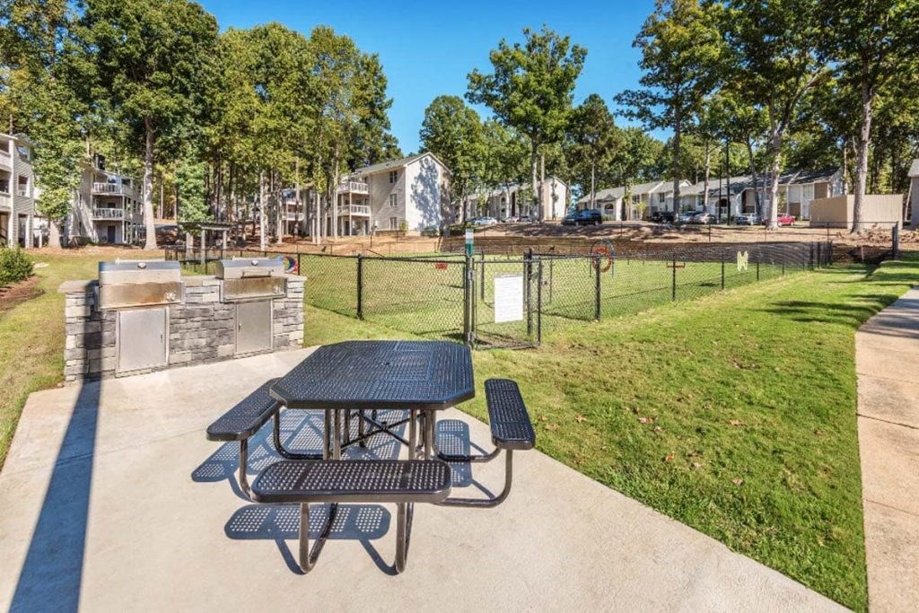 our apartments showcase a dog park with a kennel and picnic table