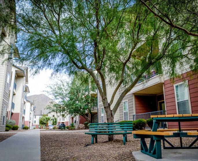 a picnic table and benches in front of a building