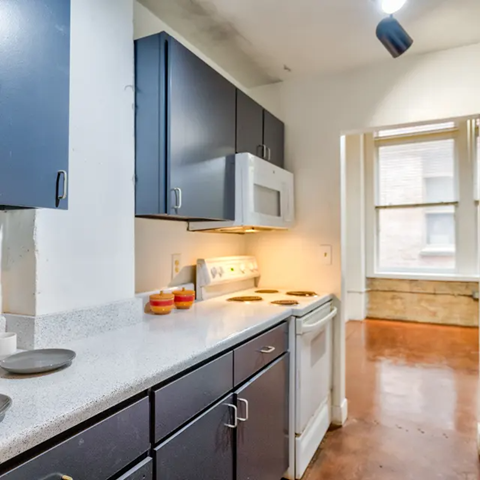 A kitchen with a white microwave above a stove and a white dishwasher.