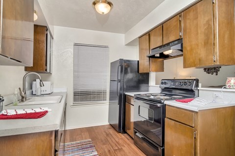 A kitchen with a black refrigerator, stove, and oven.
