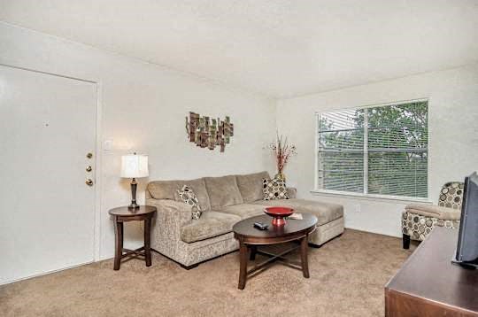 A living room with a couch, a table, and a lamp.