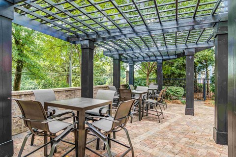 A patio with a table and chairs under a roof.