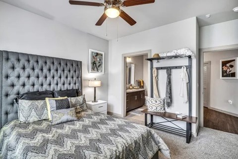 A bedroom with a large bed and a ceiling fan.