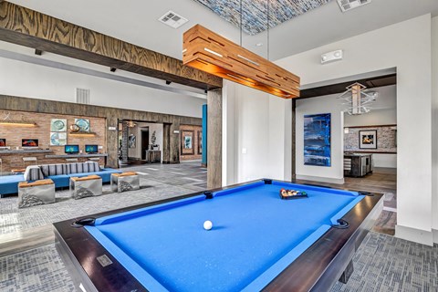 A pool table is in the middle of a room with a blue carpet.