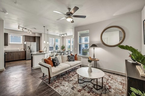 A living room with a white couch and a rug.