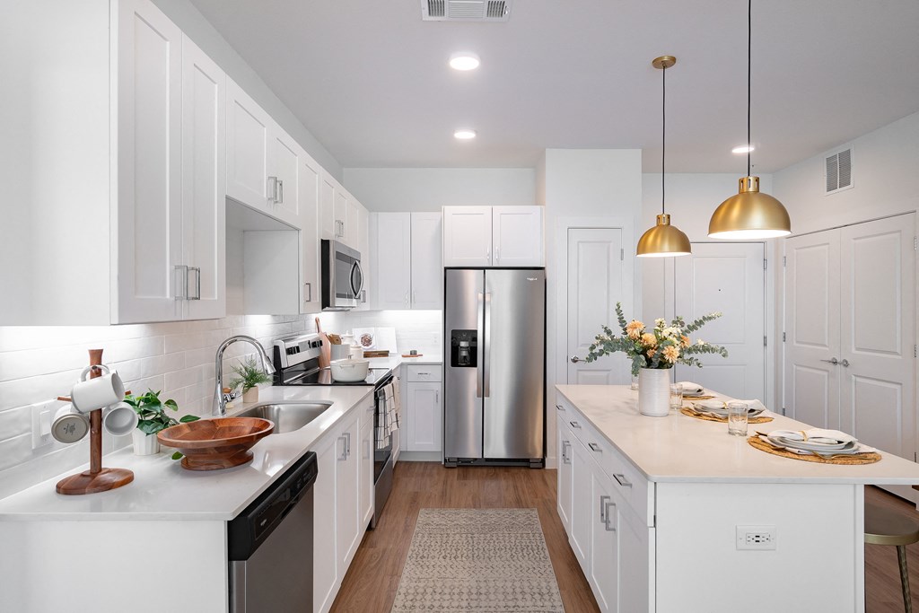 a kitchen with white cabinets and stainless steel appliances