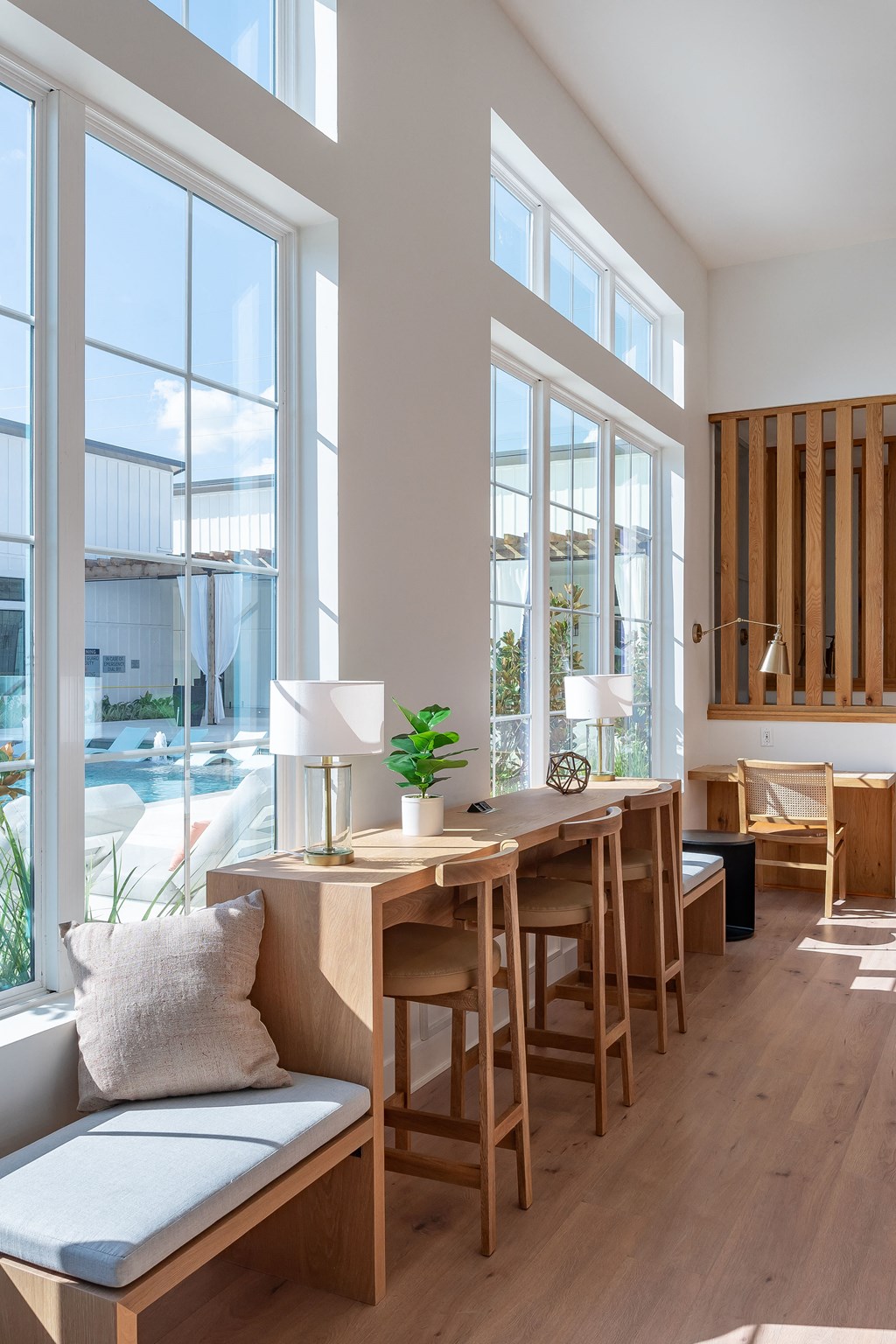 a room with large windows and a wooden table and chairs