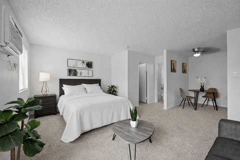 A bedroom with a large bed and a small table.