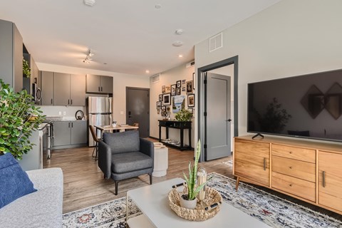 A modern living room with a grey sofa and a wooden cabinet.