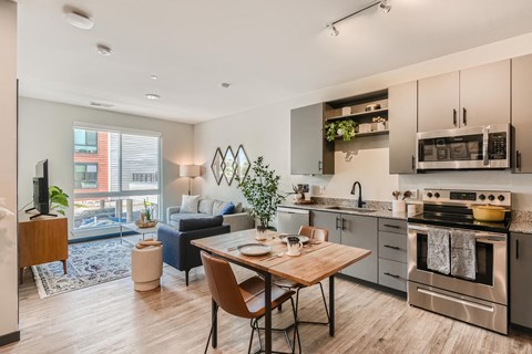 A modern kitchen with a dining table and chairs in the foreground.
