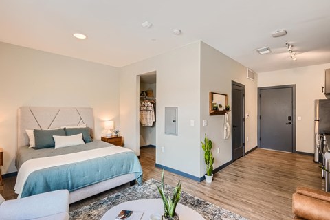 A bedroom with a bed, a couch, and a chair.
