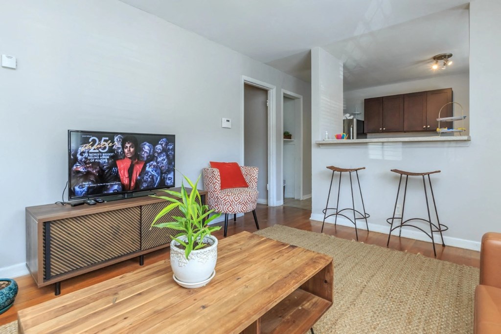 a living room with a wooden coffee table and a flat screen tv