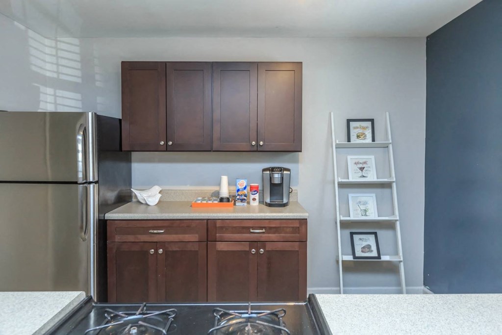 a kitchen with dark wood cabinets and a stainless steel refrigerator
