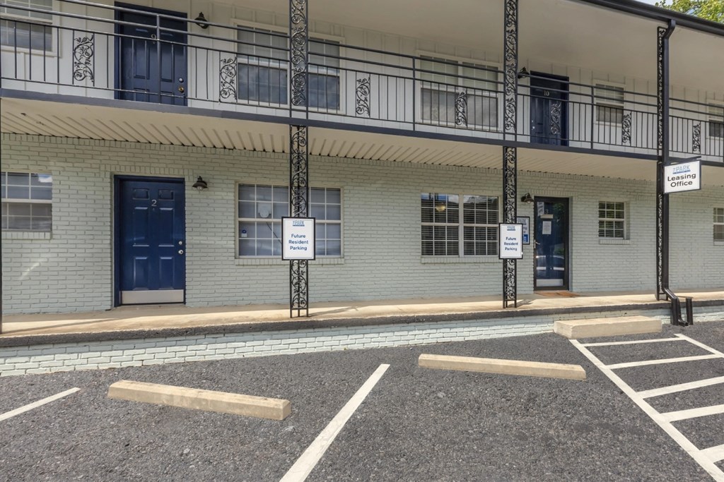 a building with blue doors and windows and a parking lot in front of it