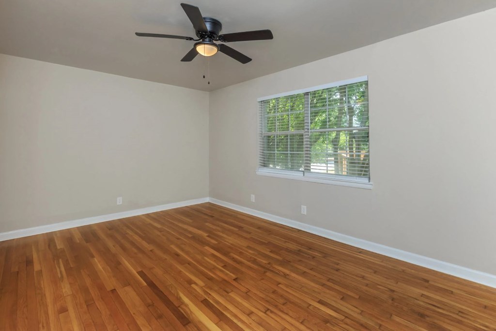 an empty room with a ceiling fan and a window