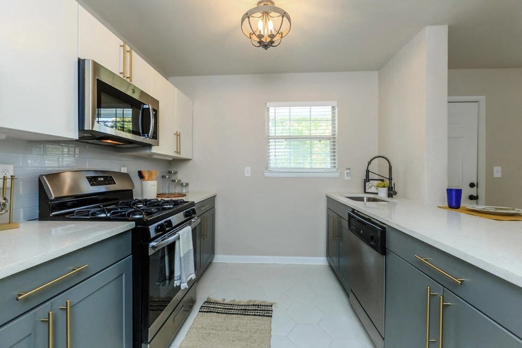 a kitchen with gray cabinets and white countertops