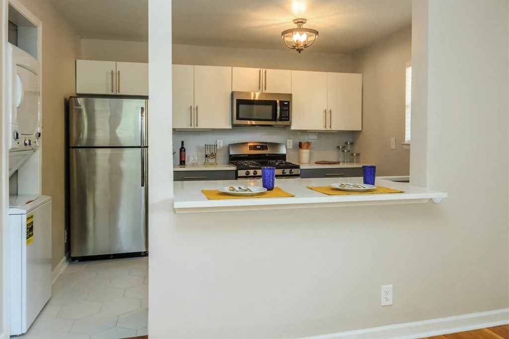 a kitchen with white cabinets and stainless steel appliances