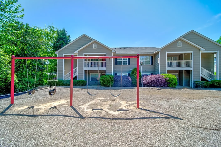 a swing set in front of an apartment building