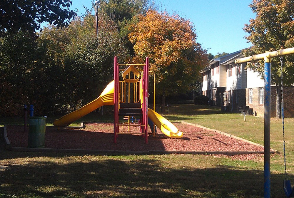 a playground with a yellow slide and red monkey bars