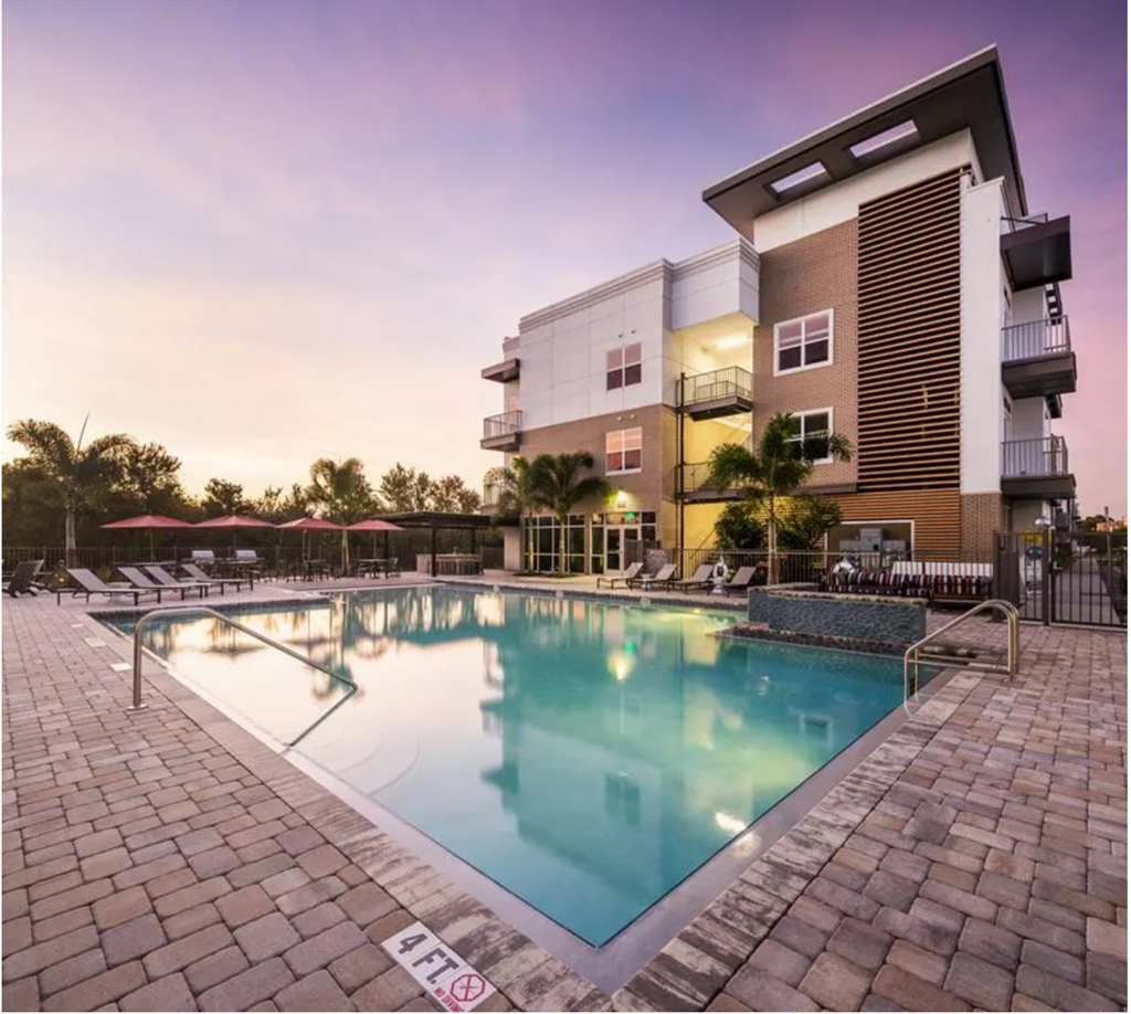 a swimming pool in front of an apartment building