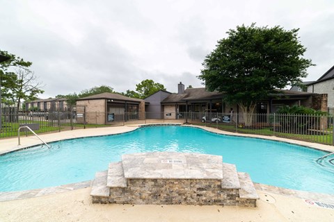 a swimming pool with a house in the background