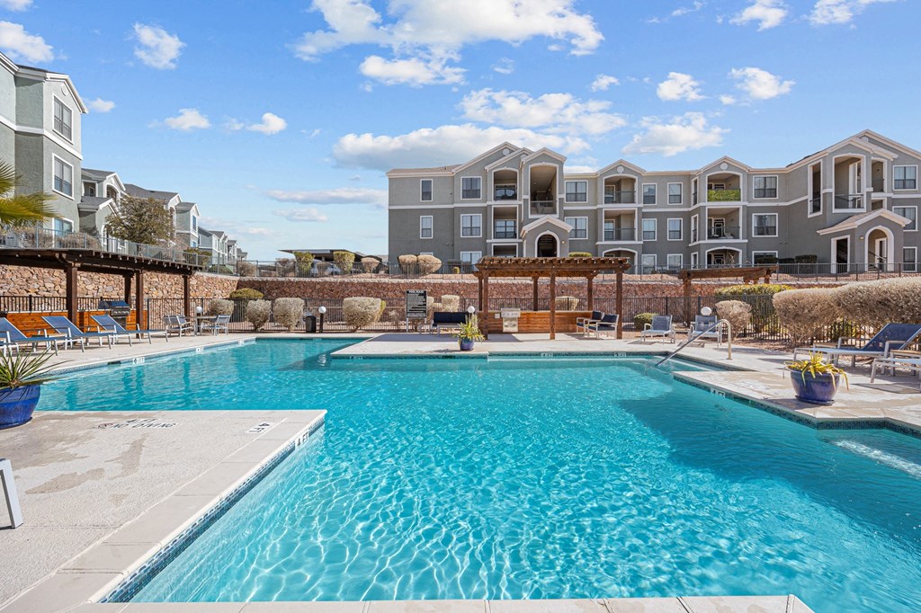 a swimming pool with an apartment building in the background