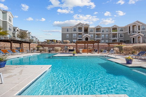 a swimming pool with an apartment building in the background