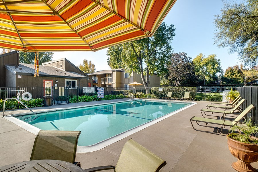 our apartments have a resort style pool with chairs and umbrellas
