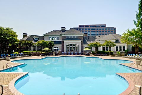 a large swimming pool with a mansion in the background