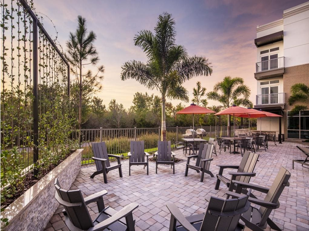 an outdoor patio with chairs and umbrellas at dusk