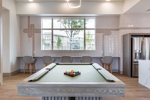 A pool table with a green felt cloth and a set of balls on it.