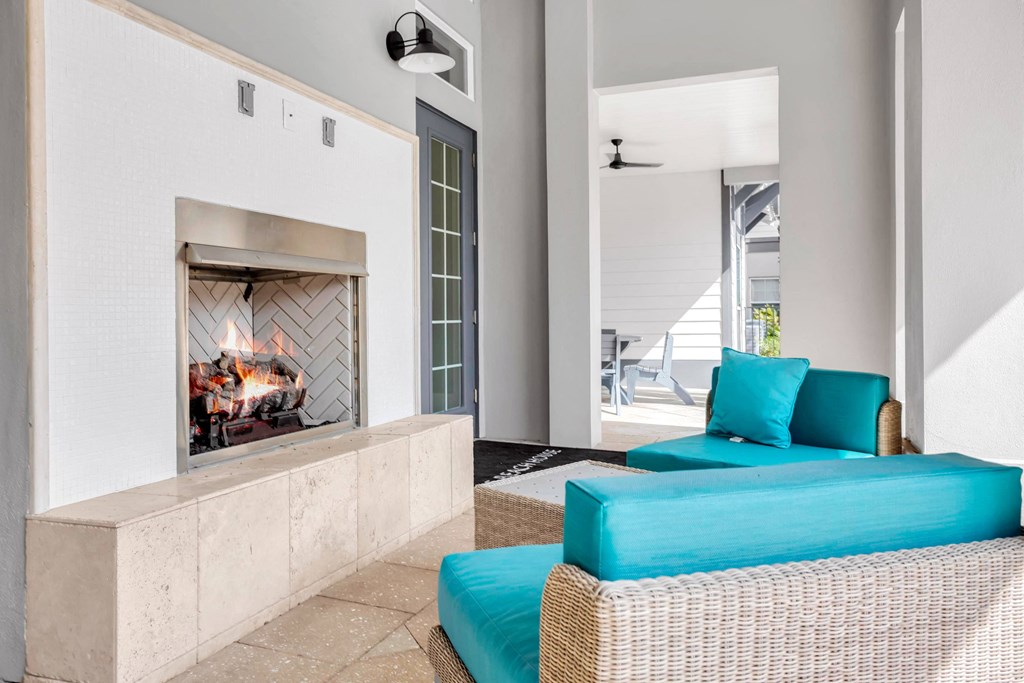 a living room with a fireplace and blue furniture