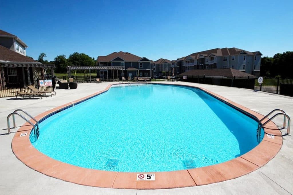 a large swimming pool with apartments in the background