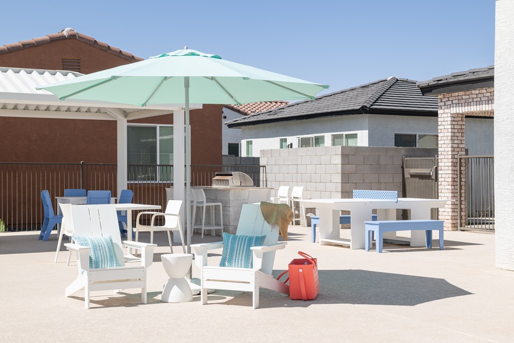 A patio with a table, chairs and an umbrella.