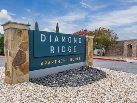 a sign apartment homes in front of a stone wall