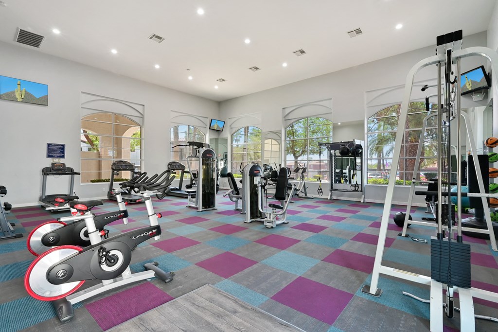 a spacious fitness center with exercise equipment and a large window