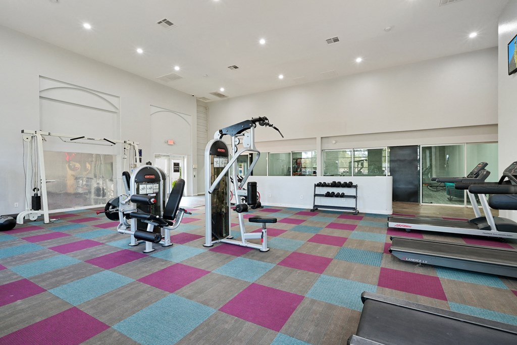 a spacious fitness center with exercise equipment and a large window