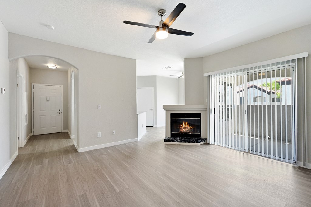 a living room with a fireplace and a ceiling fan