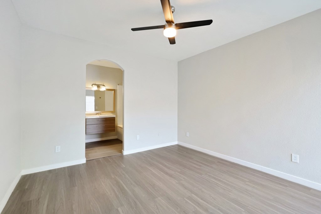 a bedroom with a ceiling fan and hardwood floors