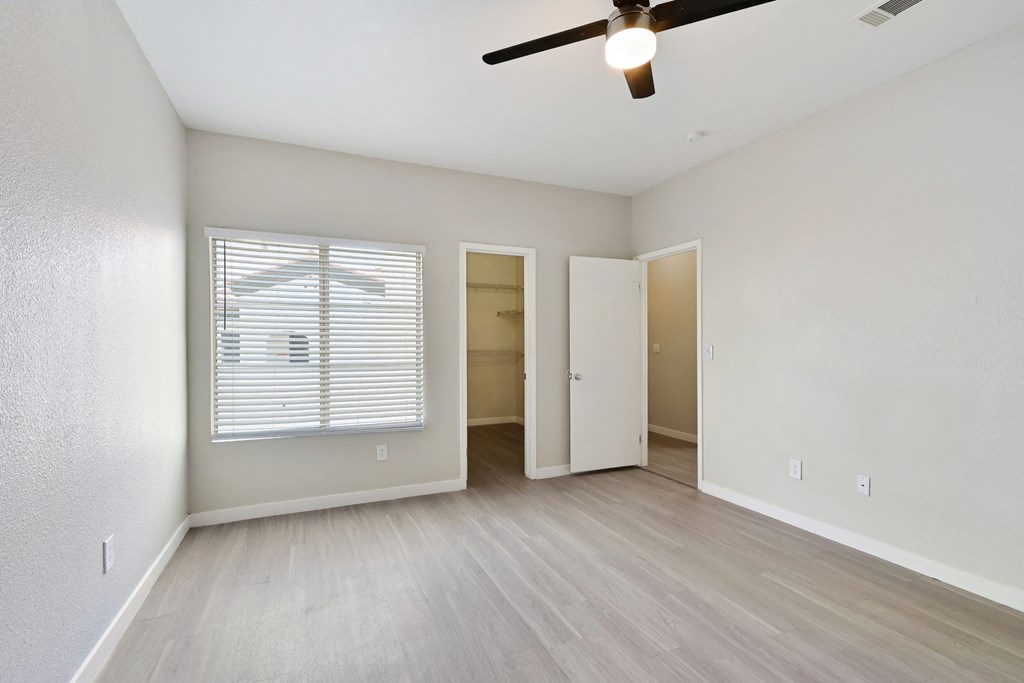 a bedroom with hardwood floors and a ceiling fan