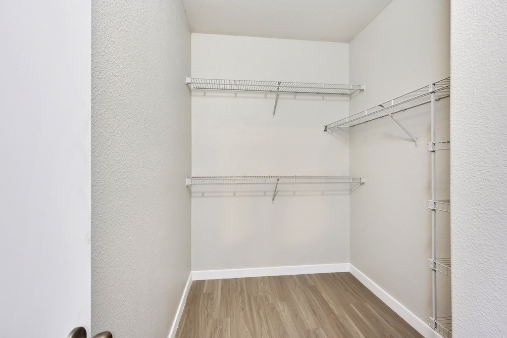 a bedroom with white walls and wood flooring