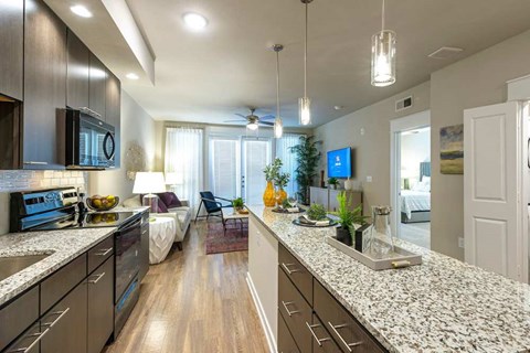 A modern kitchen with dark wood cabinets and granite countertops.