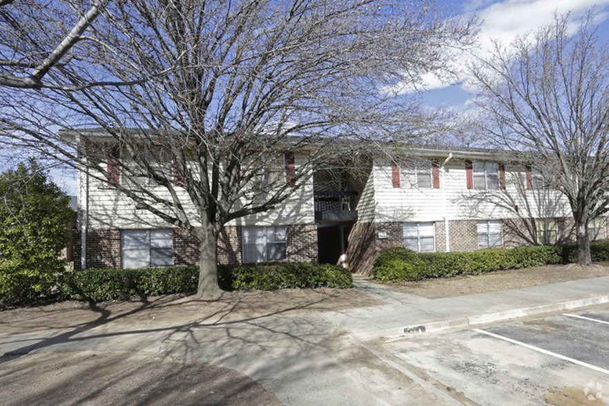 a white building with a tree in front of it