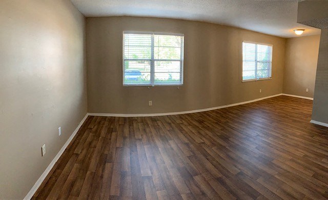 an empty living room with a hardwood floor