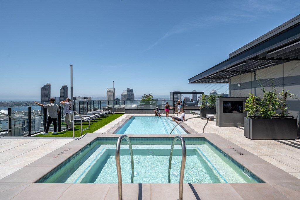 a swimming pool on the roof of a building with a city in the background