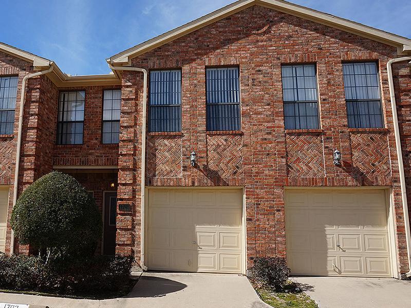 a brick house with two garage doors